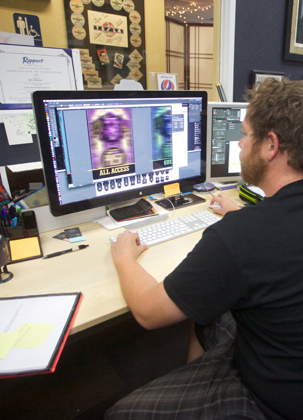 ACCESS designer preparing custom event credential artwork at a workstation